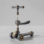 Dark grey and gold 3-in-1 kids scooter with seat, angled view